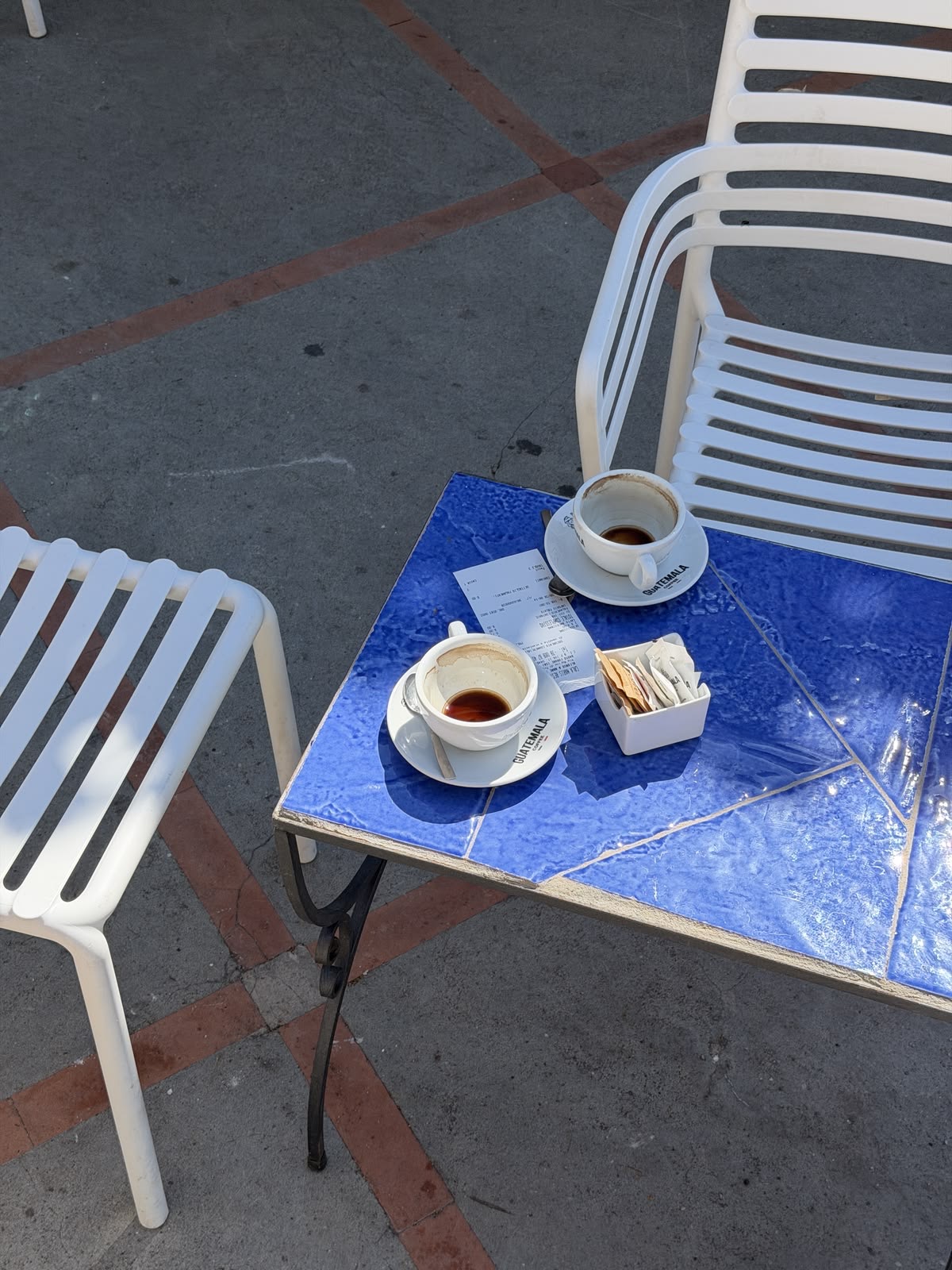 Zwei Espressotassen auf einem blau gefliesten Tisch im Freien